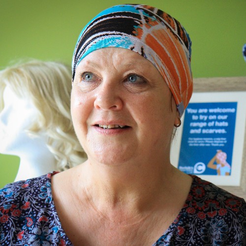 A lady wearing a brightly coloured sleep cap