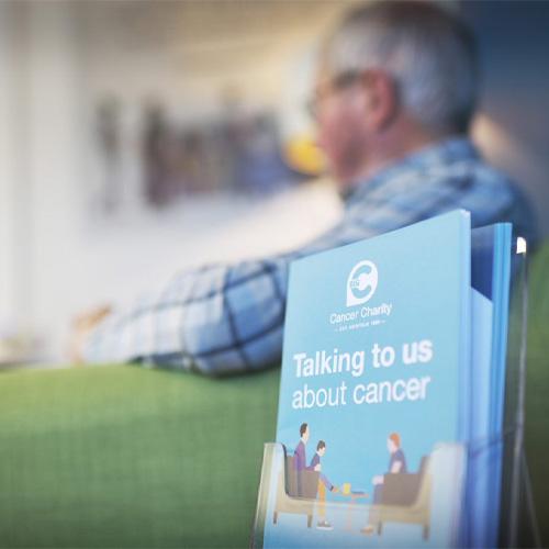 A close up of a pamphlet, reading Talking to us about cancer.