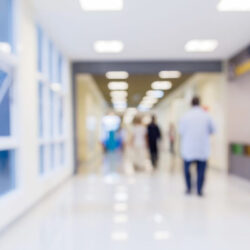 A blurred image looking down the hallway of a hospital floor.
