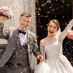 A happy newly wed couple, celebrating with confetti.