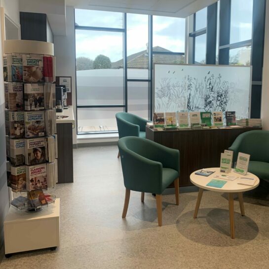 Macmillan Centre at Cromer Hospital with arm chairs, a coffee table and an array of Macmillan leaflets