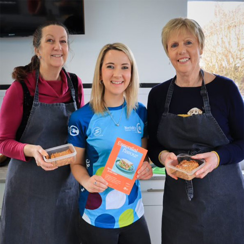 Three woman smiling holding their freshly baked goods.