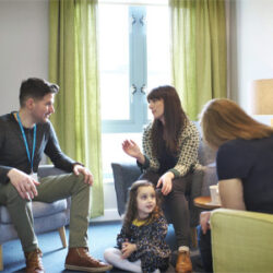 A small family receiving family therapy at a support centre.