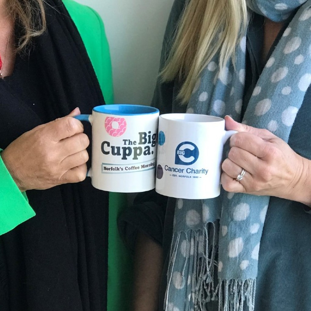 Two women holding a coffee cup for Big C's Big Cuppa