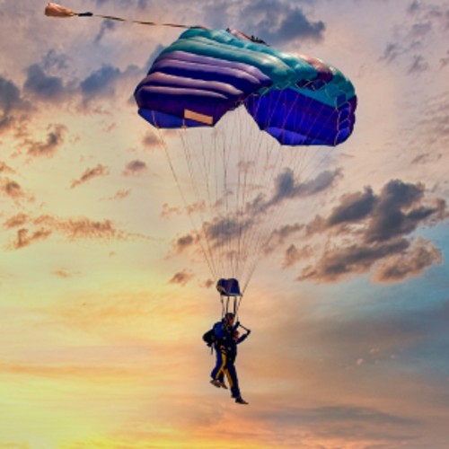 Two people in a tandem skydive with their parachute open