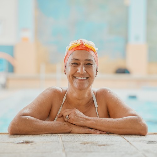 A swimmer smiling at the camera in a swimming pool