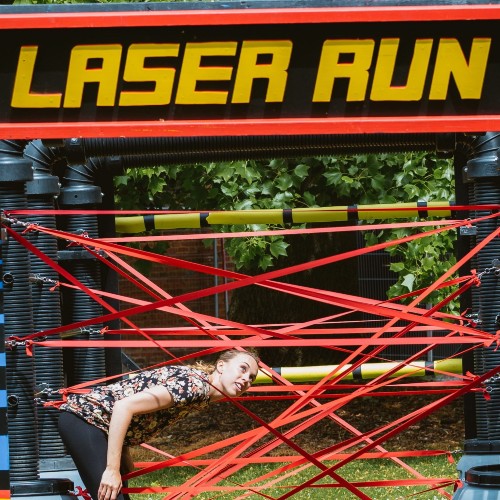 Someone going through a Laser Run game crossing through ropes
