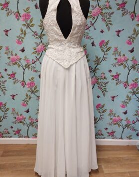 Back of Victoria Jane ivory dress, with a high neckline and flower detailing